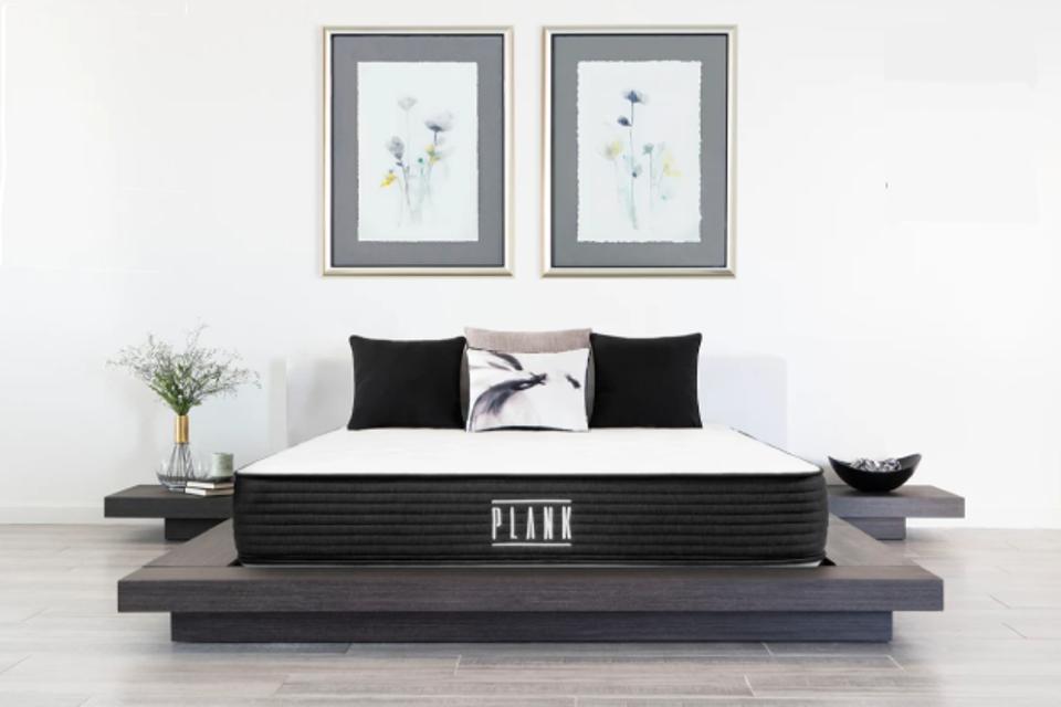 Plank Firm bed in white room on modern gray platform bed frame with two pictures above.